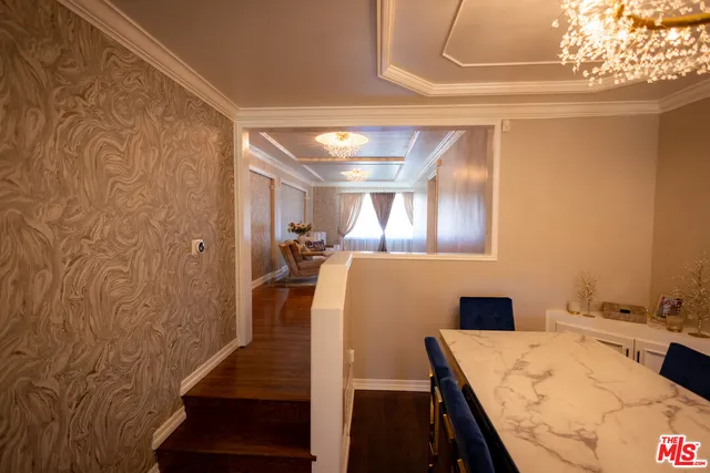 a view of a dining room with furniture a chandelier and wooden floor