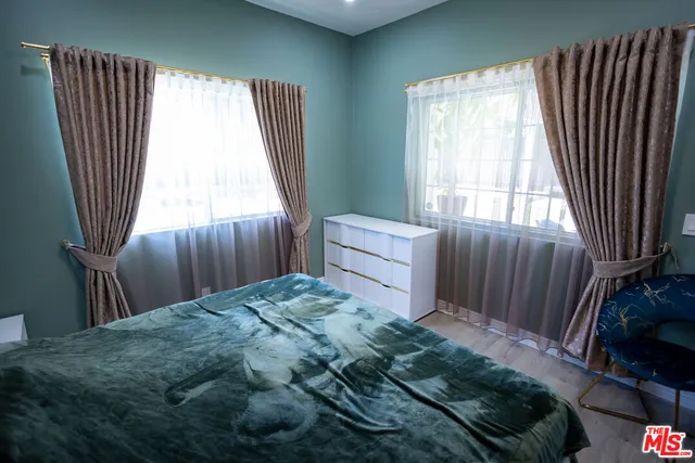 a bedroom with a large bed and wooden floor