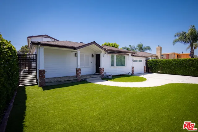 a front view of a house with yard and swimming pool