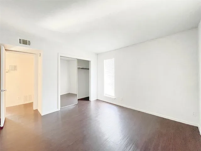an empty room with wooden floor and closet