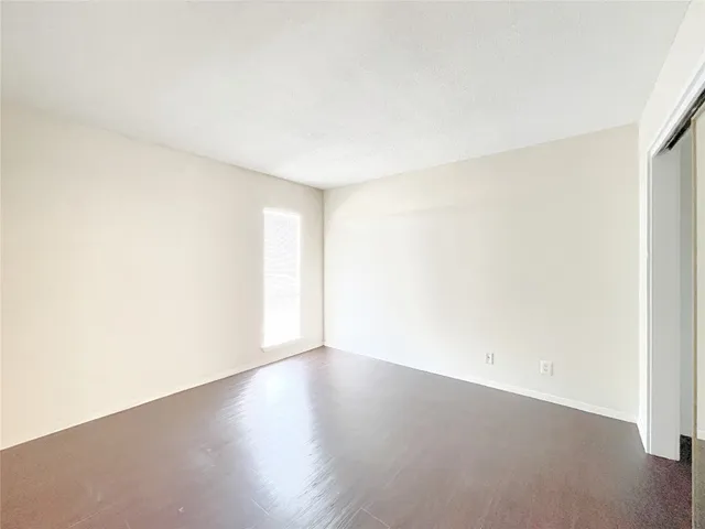 an empty room with wooden floor and white walls