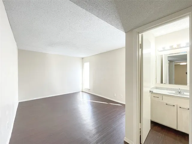 a view of a kitchen with wooden floor and white walls