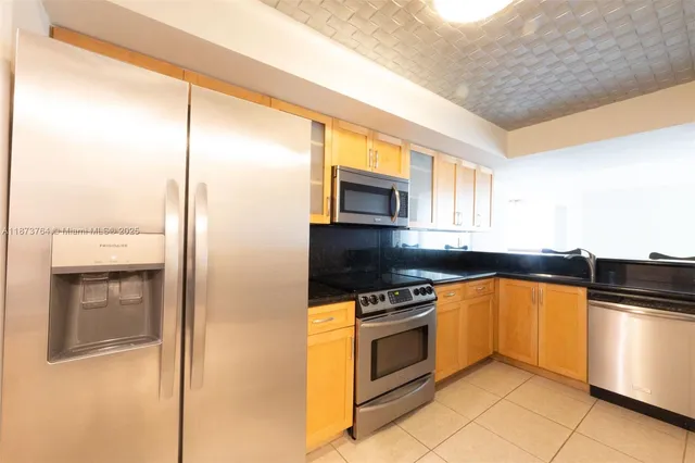 a kitchen with stainless steel appliances granite countertop a stove a sink and a refrigerator