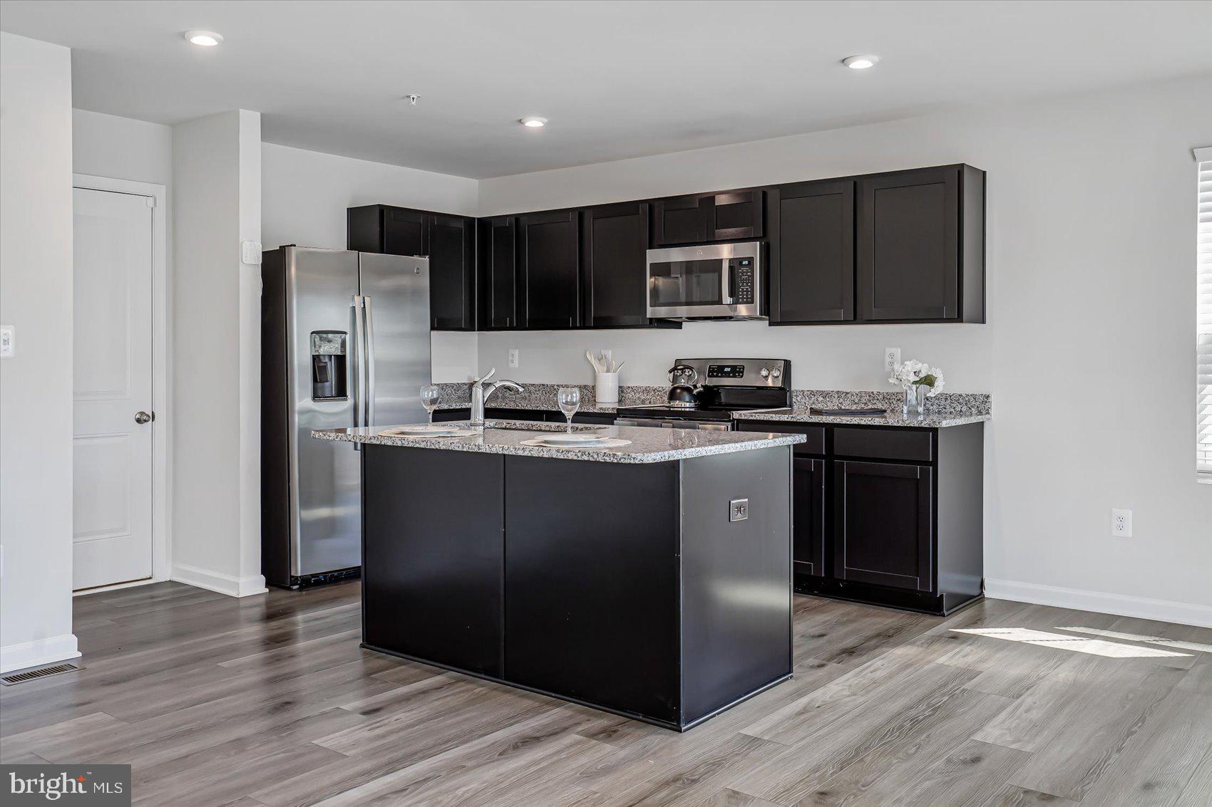 43 Olive Way Elkton, MD 21921 - Photo 12 of 44 a kitchen with stainless steel appliances granite countertop a refrigerator a sink a stove a microwave and wooden cabinets