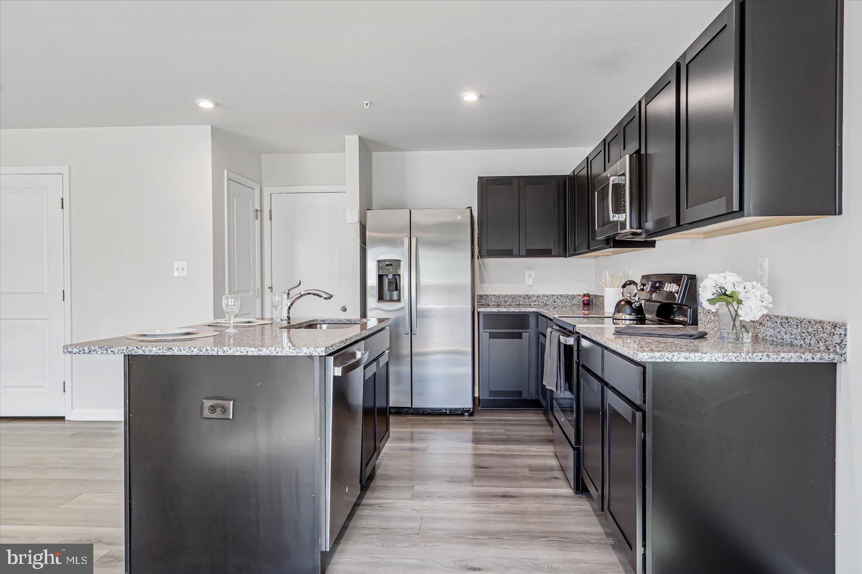 43 Olive Way Elkton, MD 21921 - Photo 14 of 44 a kitchen with stainless steel appliances granite countertop a stove top oven a sink and dishwasher a refrigerator with wooden floor