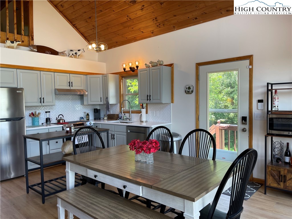 219 Lucky Alice Road Grassy Creek, NC 28631 - Photo 11 of 40 a view of a dining room with furniture window and wooden floor