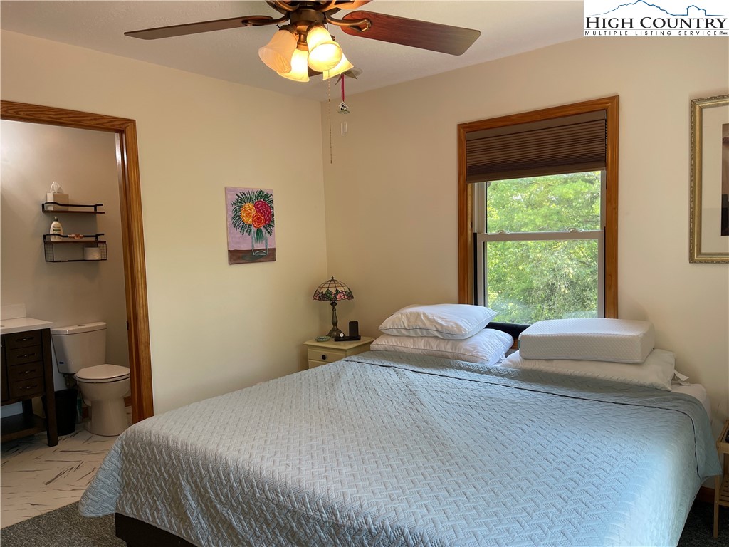 219 Lucky Alice Road Grassy Creek, NC 28631 - Photo 14 of 40 a bedroom with a bed and a chandelier
