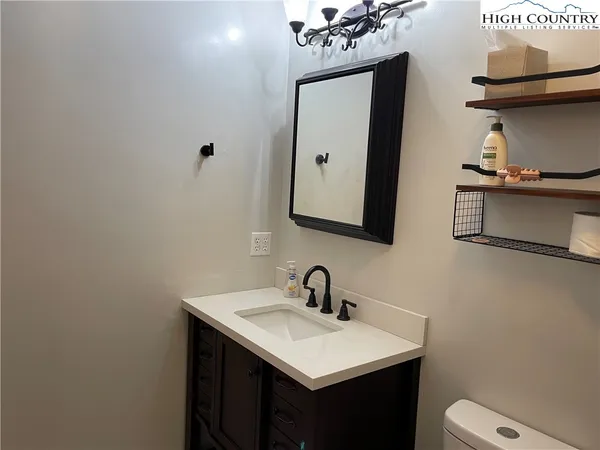 a bathroom with a sink vanity and a toilet
