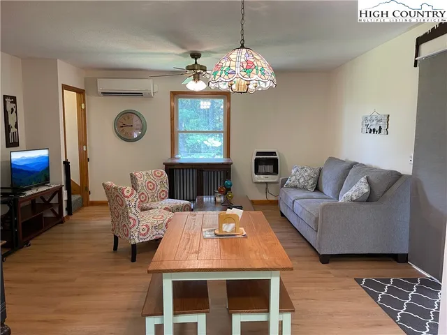 a living room with furniture a fireplace a rug and a window