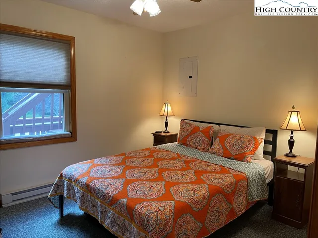 a bedroom with a bed and a lamp on dresser