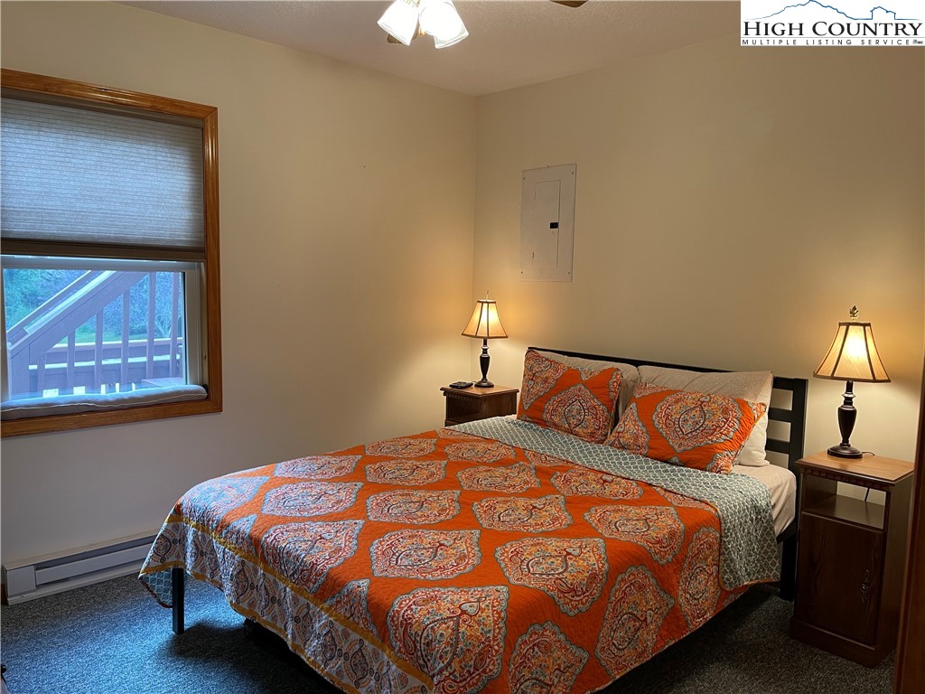 219 Lucky Alice Road Grassy Creek, NC 28631 - Photo 29 of 40 a bedroom with a bed and a lamp on dresser
