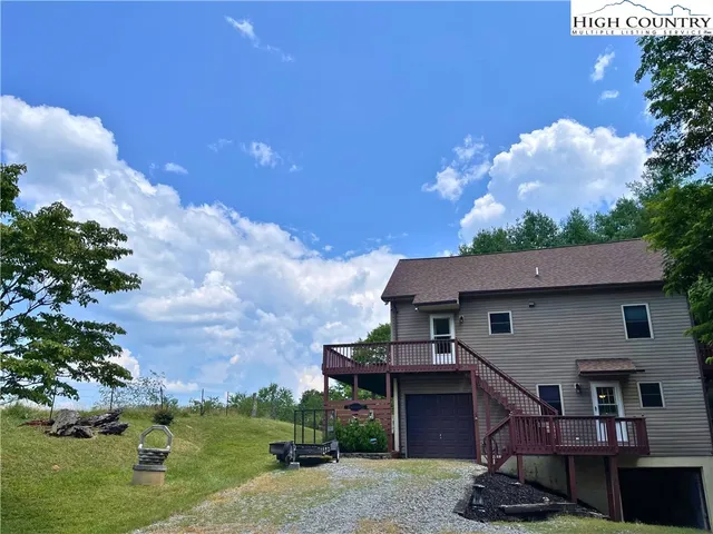 a front view of a house with a garden and trees