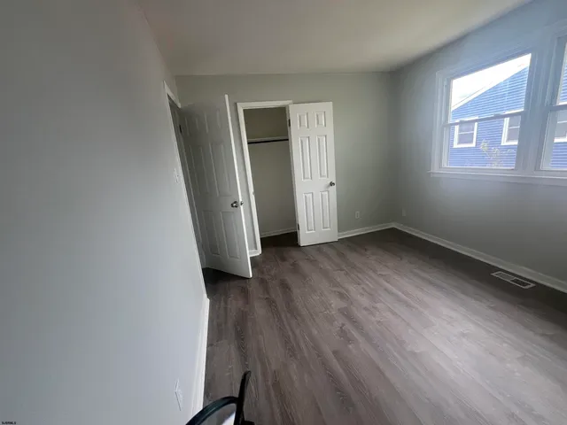 a view of a room with wooden floor and window