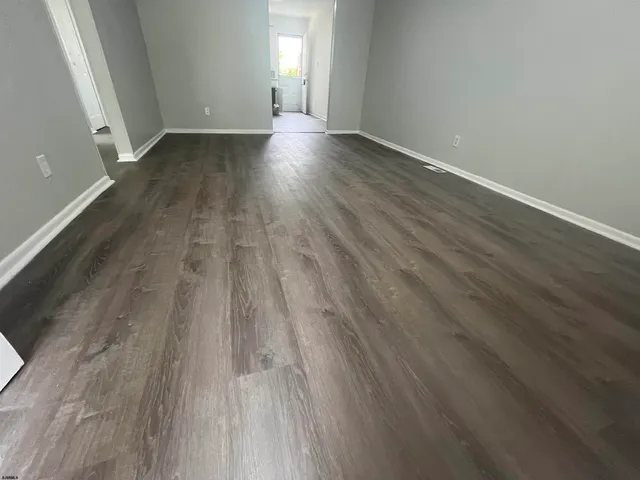 wooden floor in a hall with an empty room