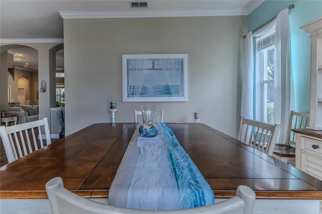 a view of a livingroom with furniture a chandelier wooden floor and a window