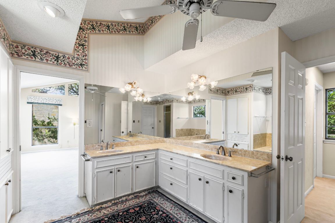 415 Dasher Drive Lakeway, TX 78734 - Photo 20 of 38 a spacious bathroom with a granite countertop sink a mirror and a shower