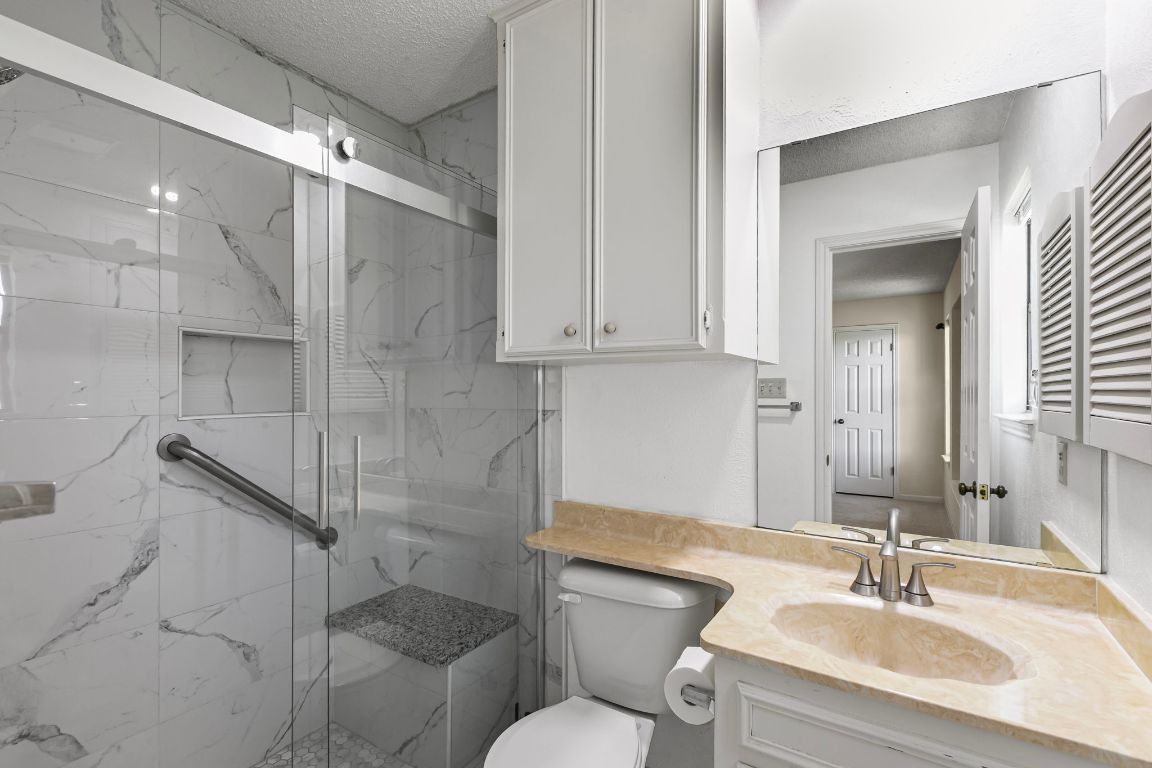 415 Dasher Drive Lakeway, TX 78734 - Photo 25 of 38 a bathroom with a sink toilet and shower