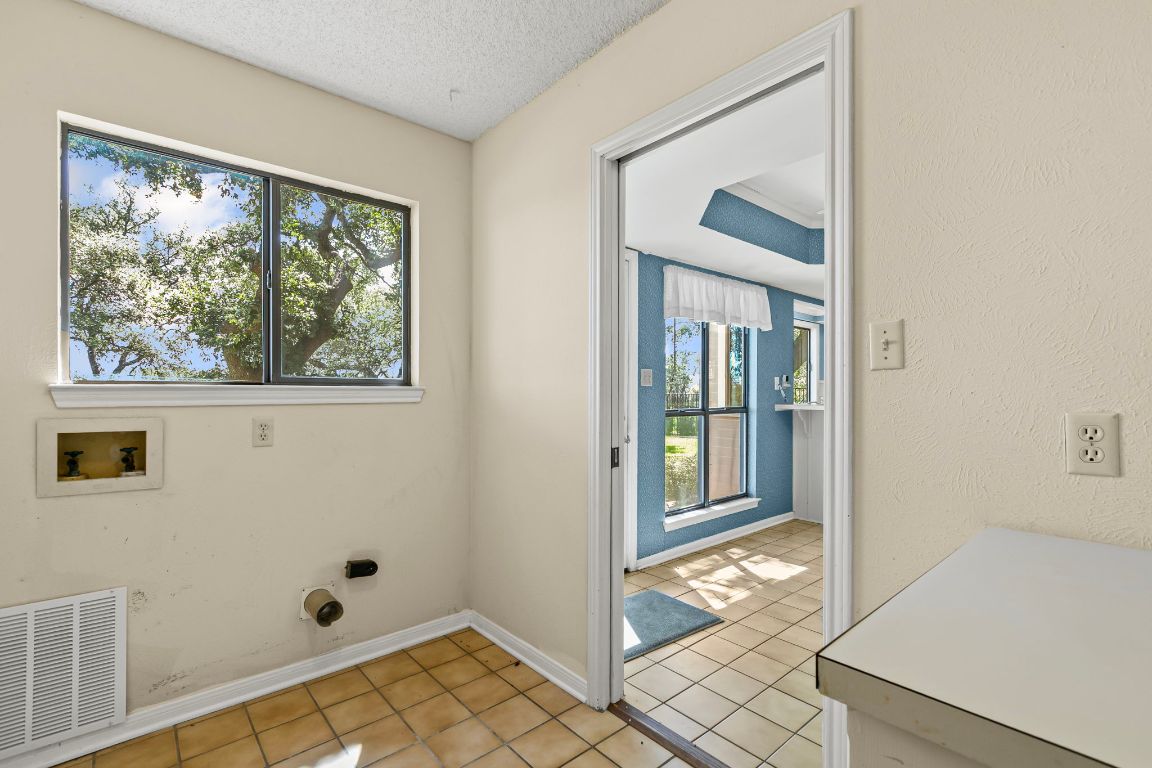 415 Dasher Drive Lakeway, TX 78734 - Photo 29 of 38 a view of a hallway with wooden floor and a livingroom with windows