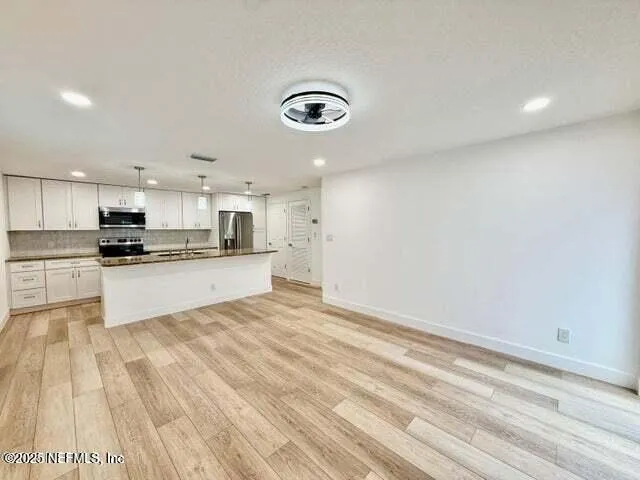 a view of kitchen with wooden floor and electronic appliances
