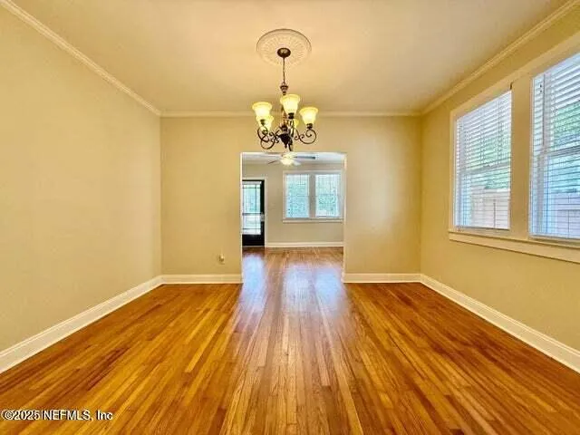 a view of a room with wooden floor and chandelier