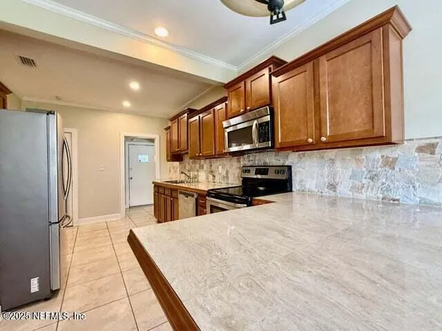 a kitchen with stainless steel appliances kitchen island granite countertop a refrigerator stove and sink