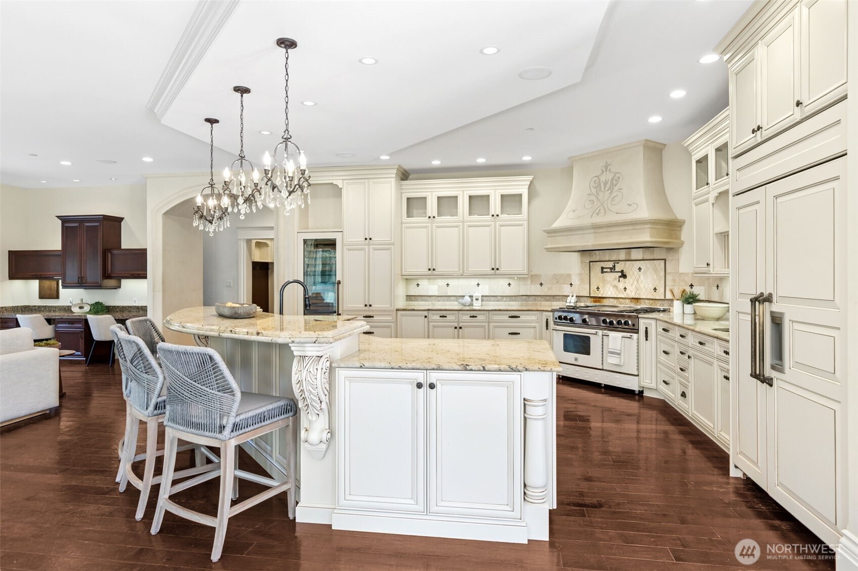 22029 238th Place Southeast Maple Valley, WA 98038 - Photo 15 of 40 a kitchen with stainless steel appliances kitchen island granite countertop a wooden floor and white cabinets