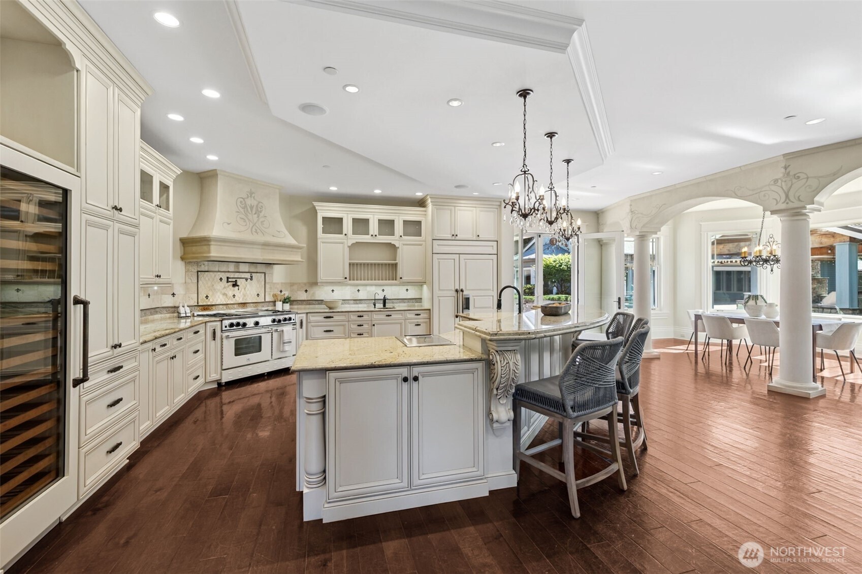 22029 238th Place Southeast Maple Valley, WA 98038 - Photo 16 of 40 a kitchen with stainless steel appliances kitchen island granite countertop a stove a sink dishwasher and a dining table with wooden floor