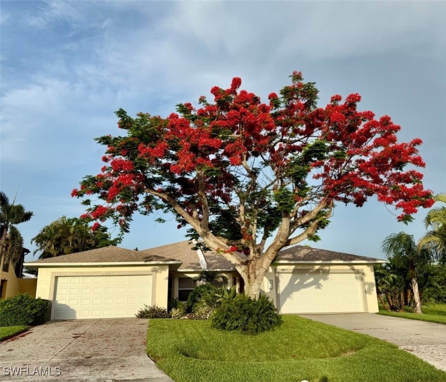 5013 Southwest 16th Place Cape Coral, FL 33914 - Photo 1 of 50 a front view of a house with a flower garden