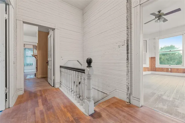 a view of a hallway with wooden floor and staircase