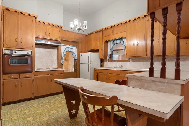 a kitchen with stainless steel appliances granite countertop a kitchen island a stove a table and chairs