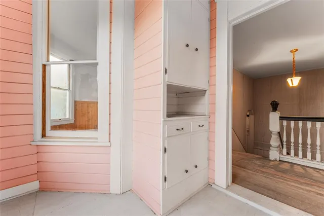 a view of a hallway with entryway wooden floor and windows