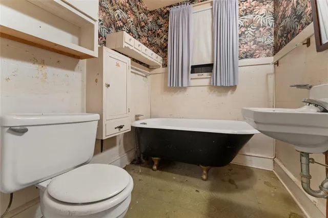 a bathroom with a toilet a sink and a window