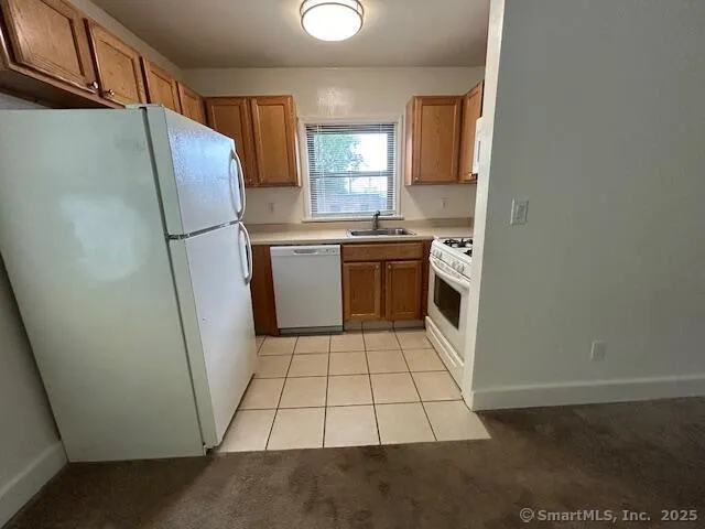 a kitchen with a refrigerator sink and window