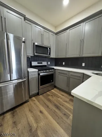 a kitchen with white cabinets stainless steel appliances and a sink