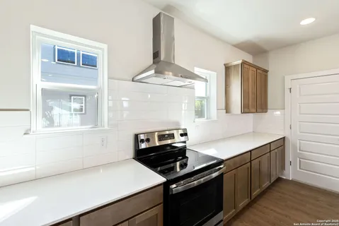 a kitchen with a stove and a white cabinets