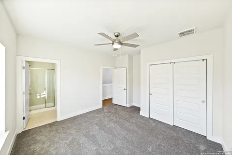 a view of a livingroom with a ceiling fan and closet area