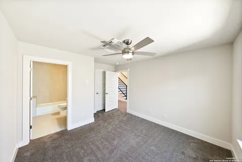 a view of an empty room and chandelier fan