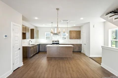 a large kitchen with a lot of counter space and wooden floor