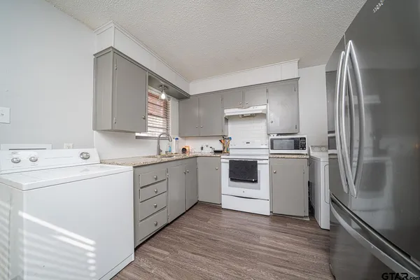 a kitchen with white cabinets sink and white appliances