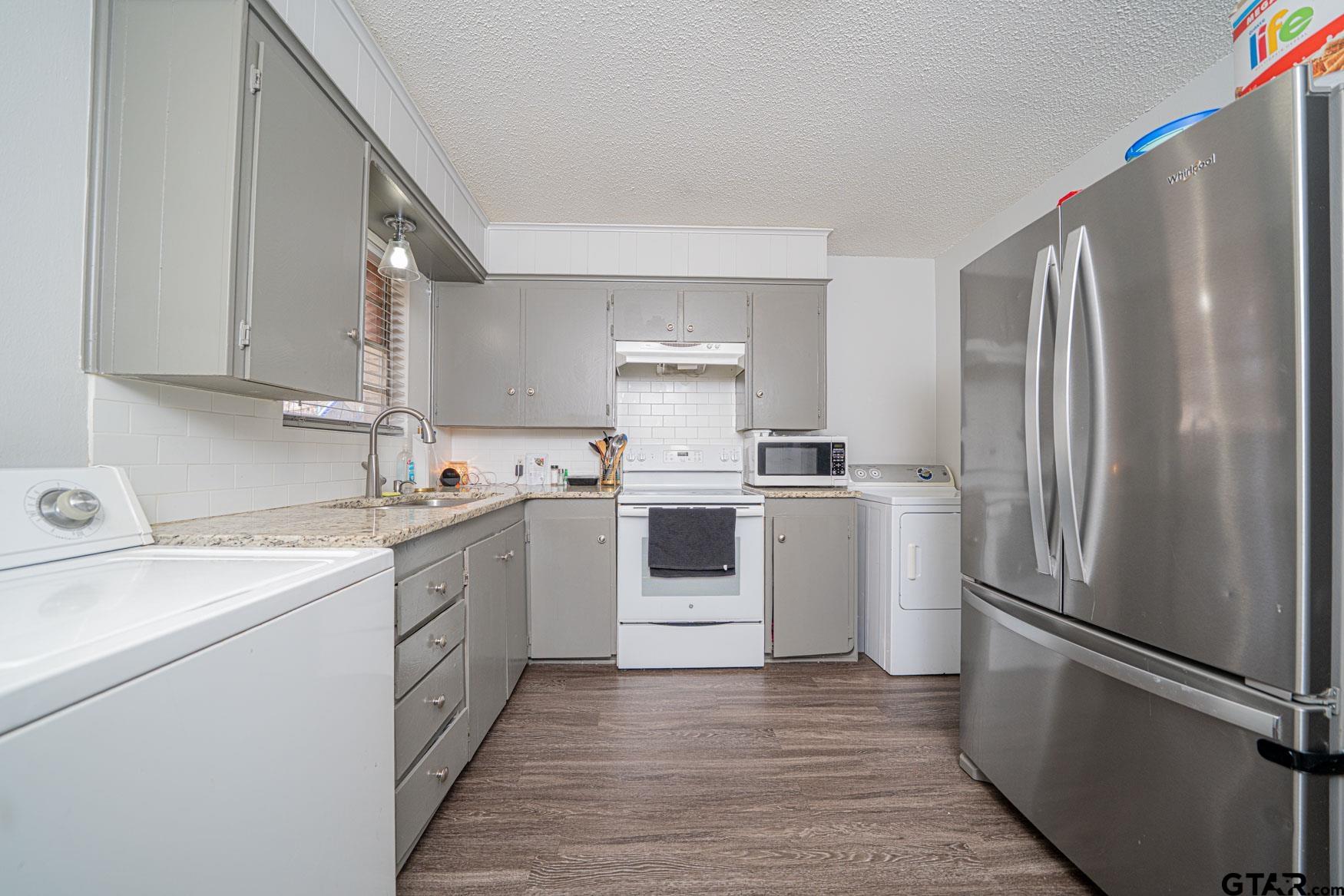 603 Waggoner Street Longview, TX 75604 - Photo 13 of 22 a kitchen with a white refrigerator sink and cabinets