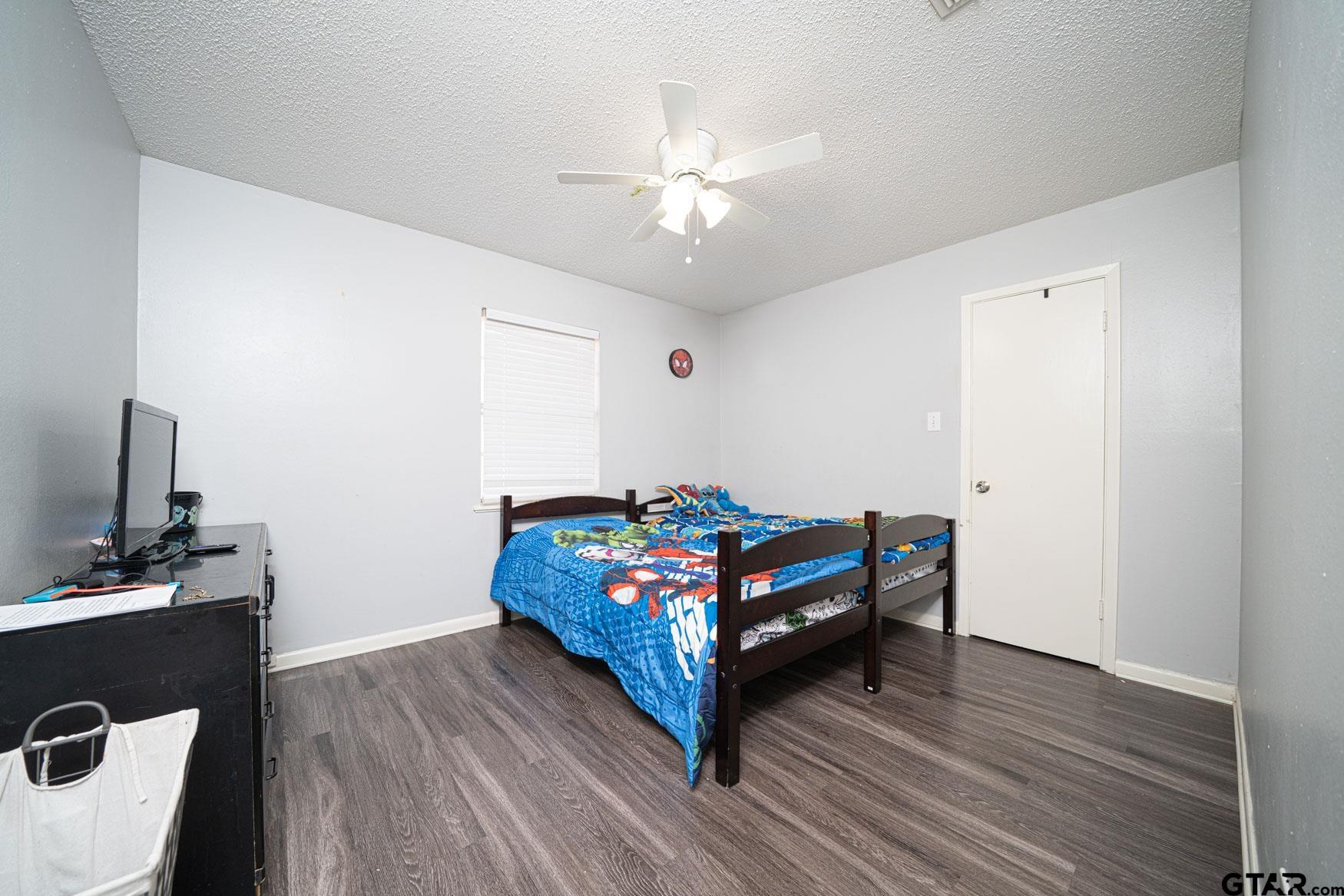 603 Waggoner Street Longview, TX 75604 - Photo 16 of 22 a bedroom with a bed and a chandelier