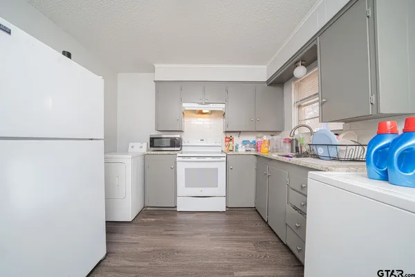 a kitchen with white cabinets and white appliances
