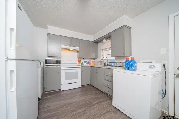 a kitchen with white cabinets and white appliances