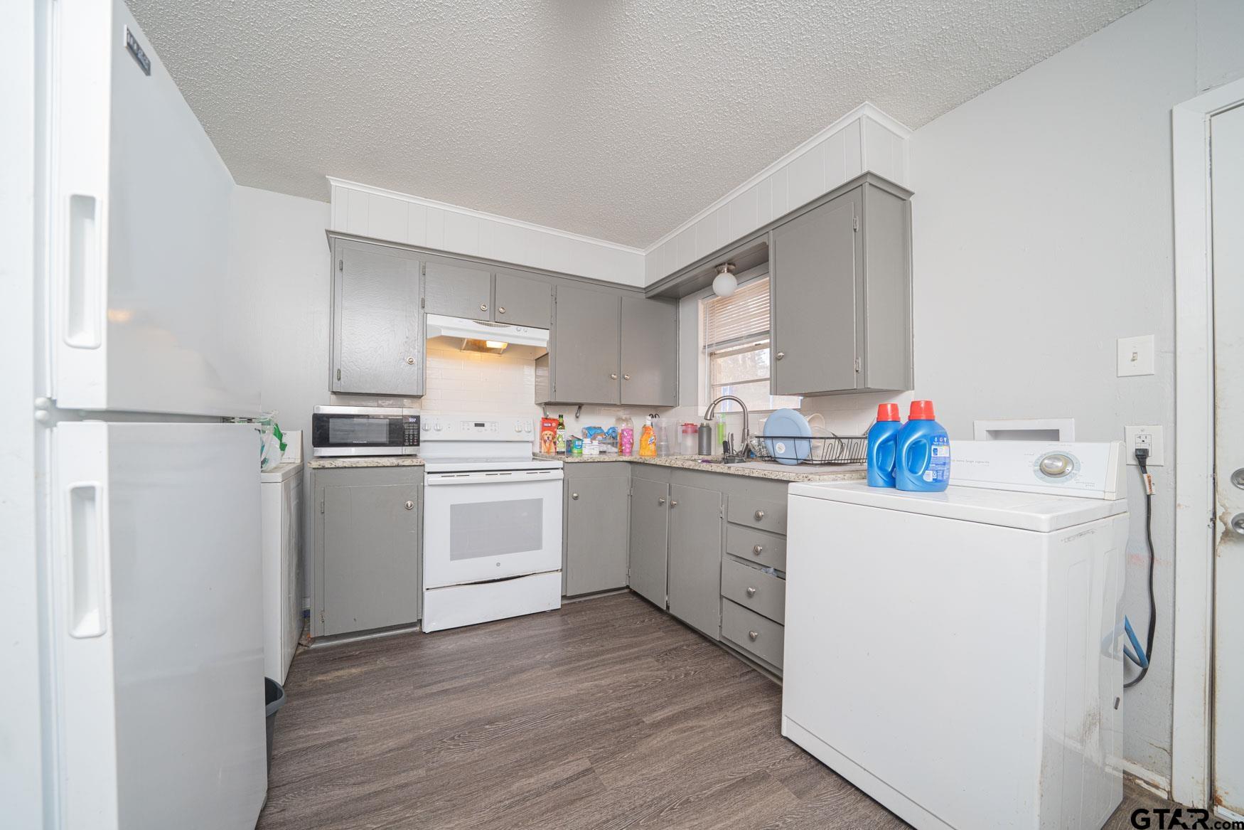 603 Waggoner Street Longview, TX 75604 - Photo 5 of 22 a kitchen with white cabinets and white appliances