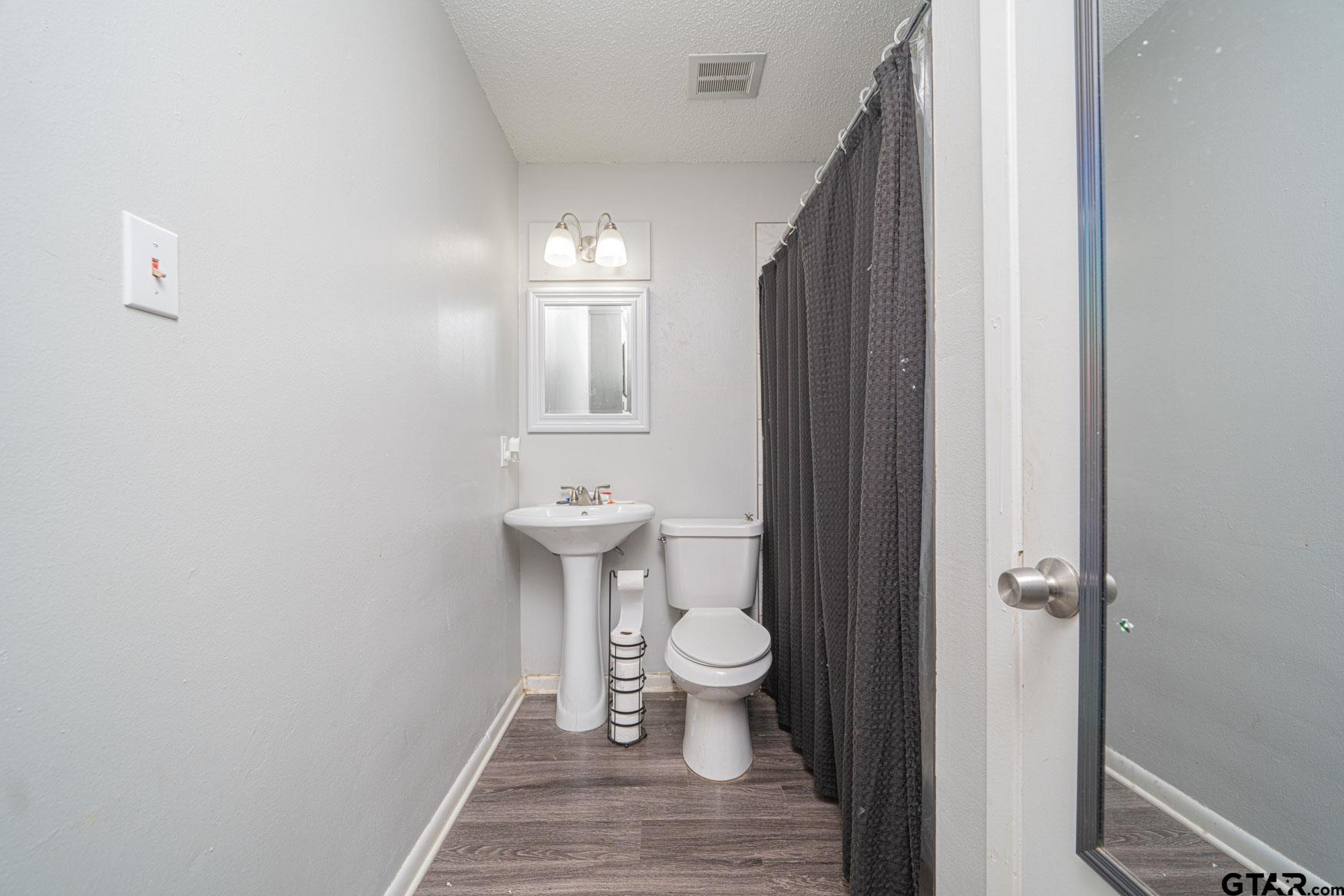 603 Waggoner Street Longview, TX 75604 - Photo 7 of 22 a bathroom with a sink and toilet