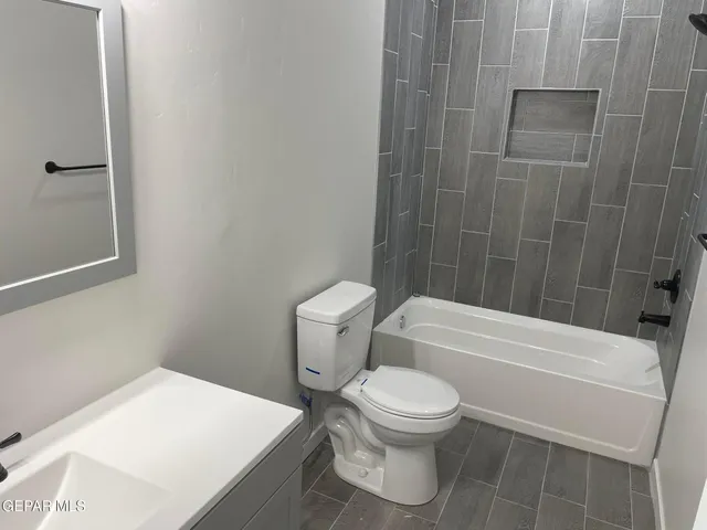 a white toilet and tub sitting next to a bathroom sink