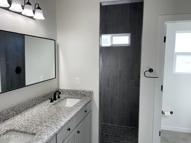a bathroom with a granite countertop sink and a mirror