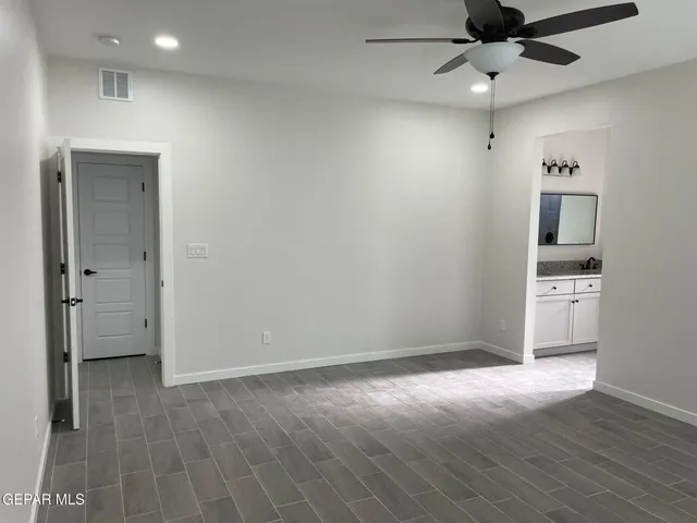 an empty room with cabinet and a ceiling fan