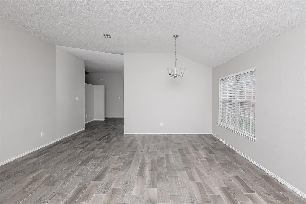 7417 Snow Ridge Drive Fort Worth, TX 76133 - Photo 2 of 16 wooden floor in an empty room with a window