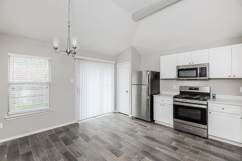 7417 Snow Ridge Drive Fort Worth, TX 76133 - Photo 6 of 16 a kitchen with stainless steel appliances a stove a refrigerator and a microwave